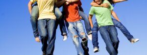 Image of a group of adolescents giving each other piggy back rides showing the importance of support that can come from therapy for teenagers in Baltimore, MD. If you are looking for a therapist 