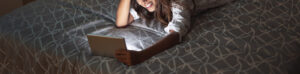 Image of a woman laying in bed talking on a tablet to a therapist for teens in Washington D.C. Your teen can start building healthy skills while in therapy for teenagers or counseling for teens in Washington D.C. and Baltimore, MD.